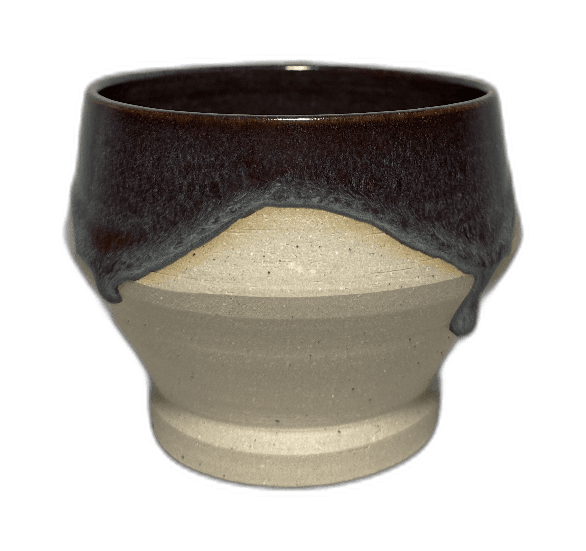 A dark-glazed ceramic bowl photographed in the studio